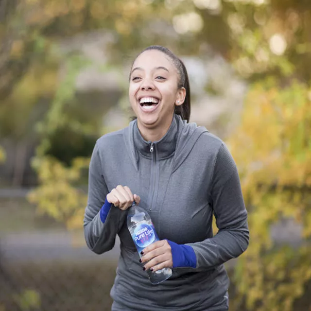 woman jogging with nestle pure life water bottle