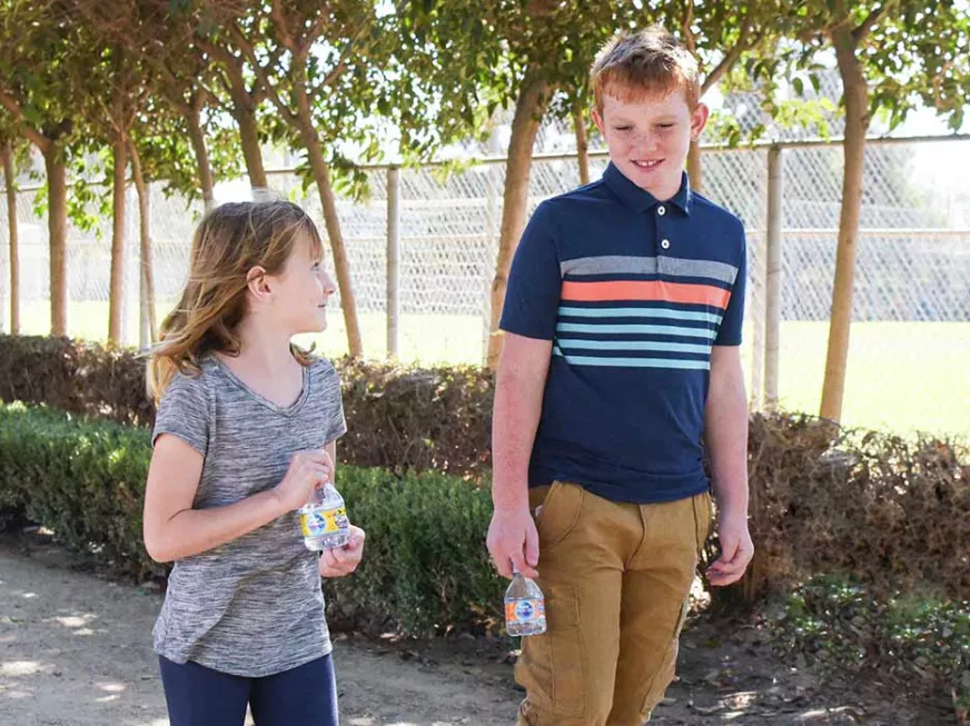 Kids drinking water while doing outdoor activities 