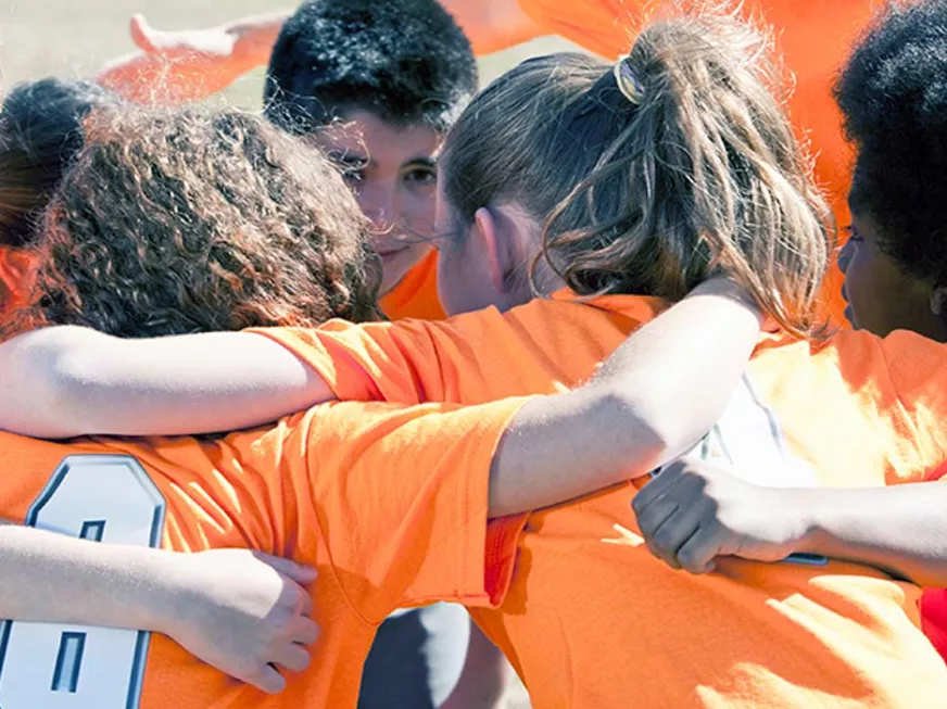 children drinking water while playing soccer