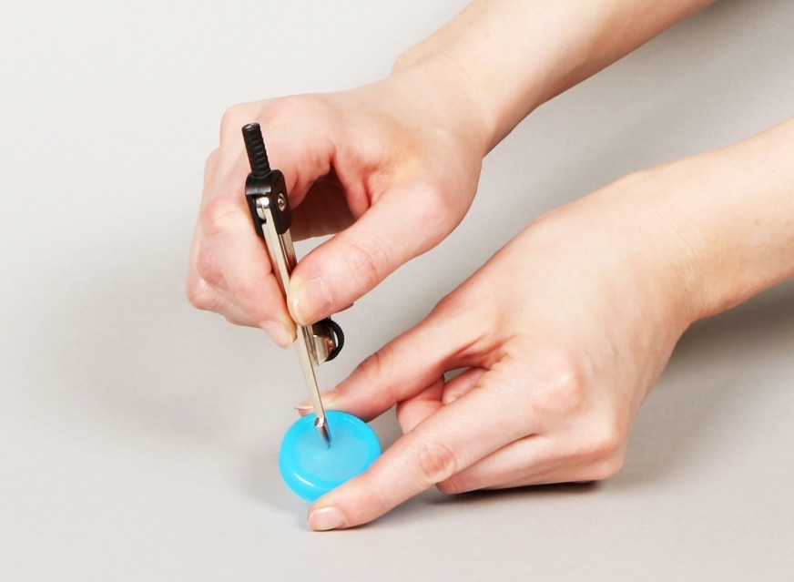 Percer un trou dans une bouteille d’eau pour fabriquer une horloge hydraulique