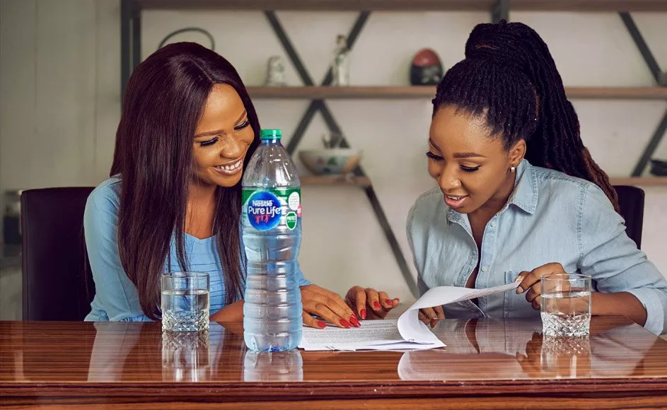 Two ladies sharing a bottle of Nestle Pure Life Premium drinking water