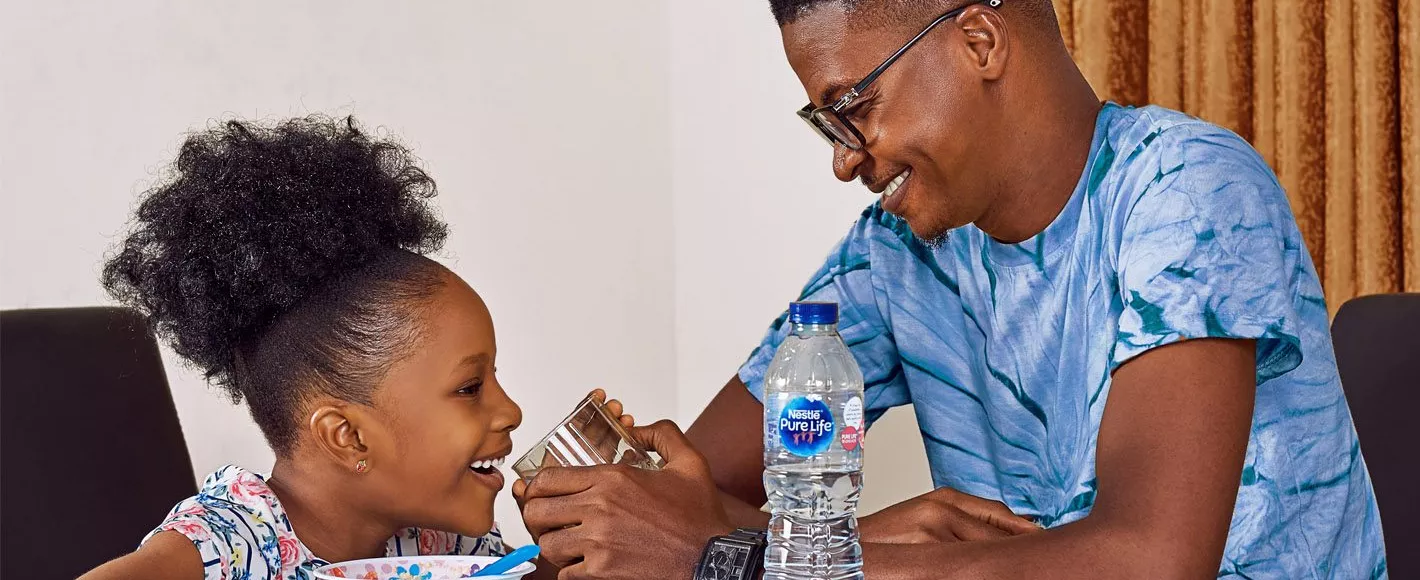 Man sharing Nestle Pure Life drinking water with daughter