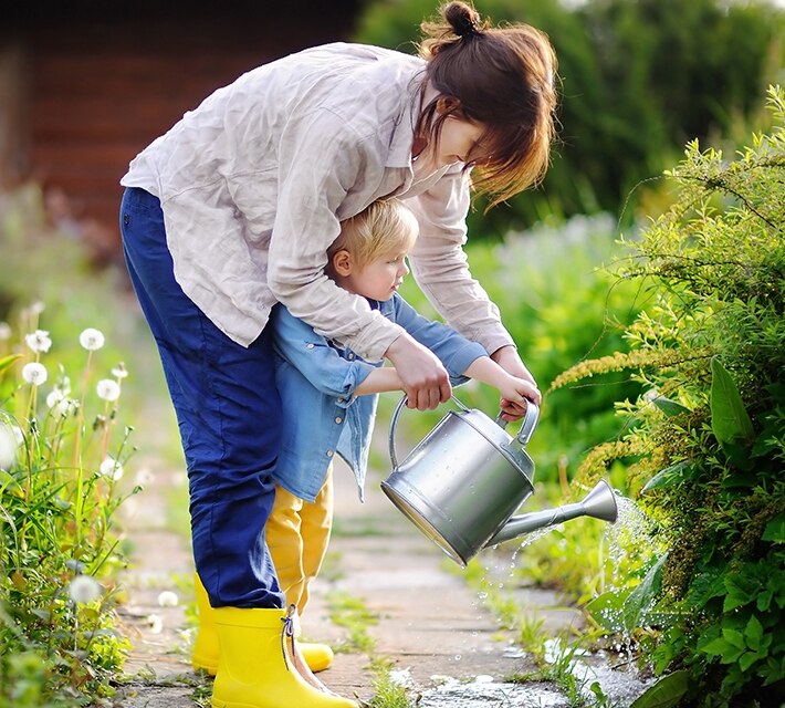 nestle pure life kid and mother watering the plant