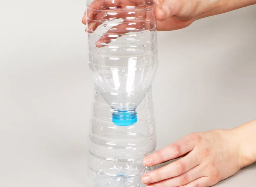 Inverting a cut water bottle for a water clock craft