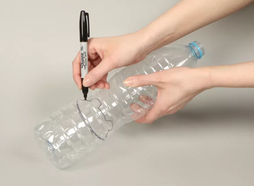 Marking the line on a empty plastic bottle to mark the polar bear face