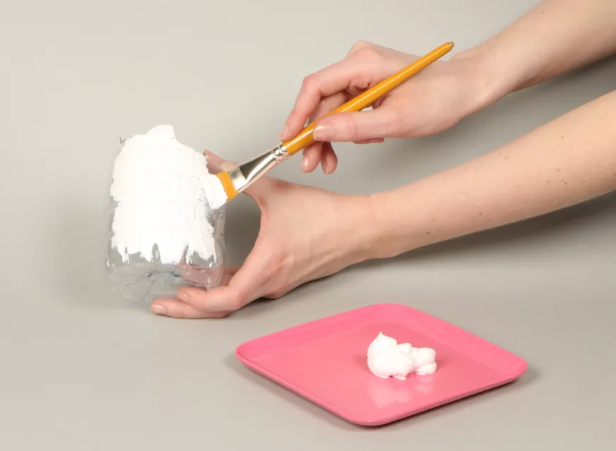 Painting the outside of the bottle with white acrylic paint