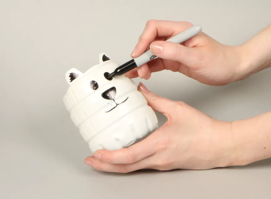 Decorating the polar bear face using a black marker