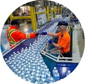 workers inspecting water bottles on production line